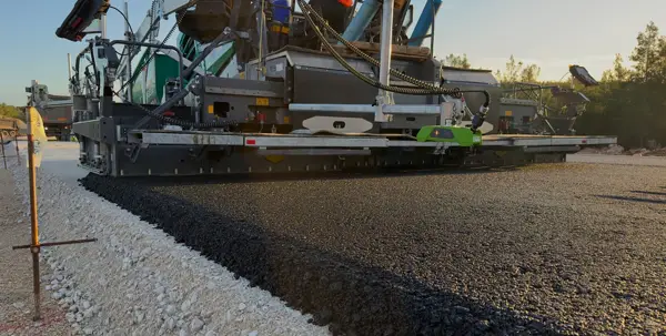 Asphalt paver laying a new surface course for commercial asphalt paving
